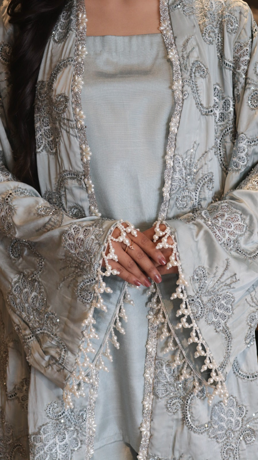 Elegant outfit with a detailed embroidered jacket over a light blue dress