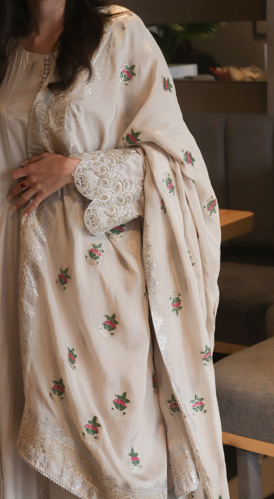 Cream-colored embroidered traditional outfit with a matching shawl
