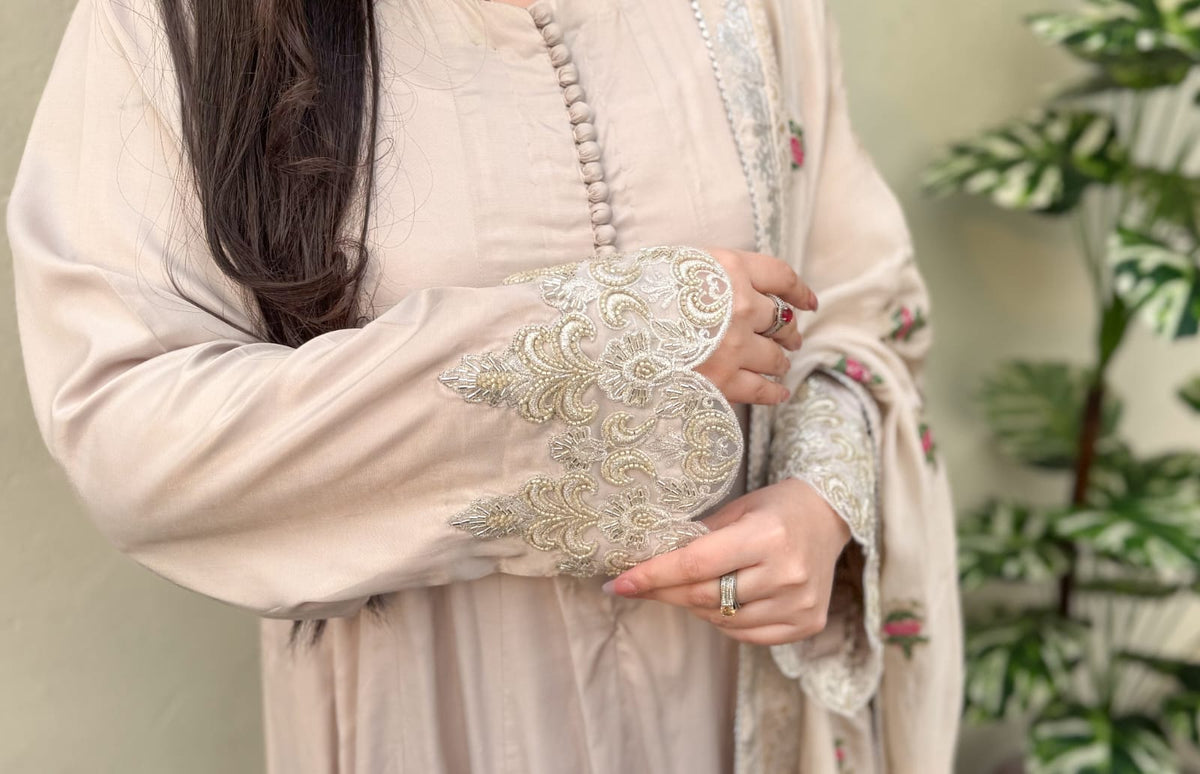 Light-colored embroidered outfit with a blurred background